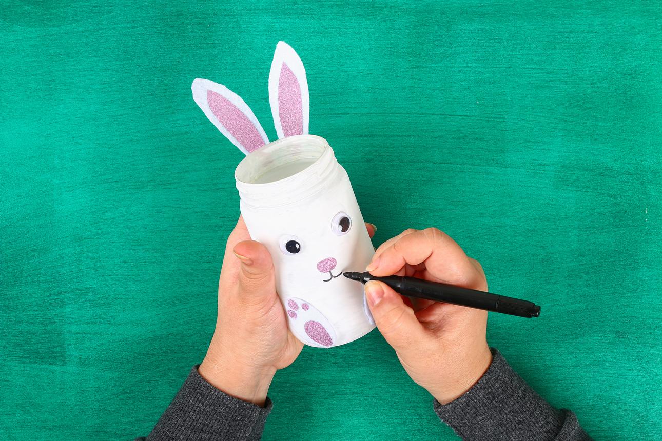 DIY Easter vase bunny from glass jar, felt, googly eyes on a green background