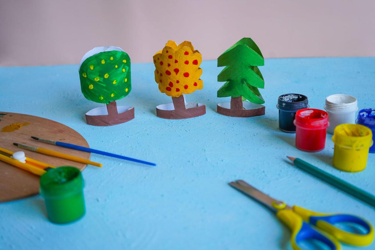 Kids craft trees out of recycling toilet paper roll, zero waste concept.