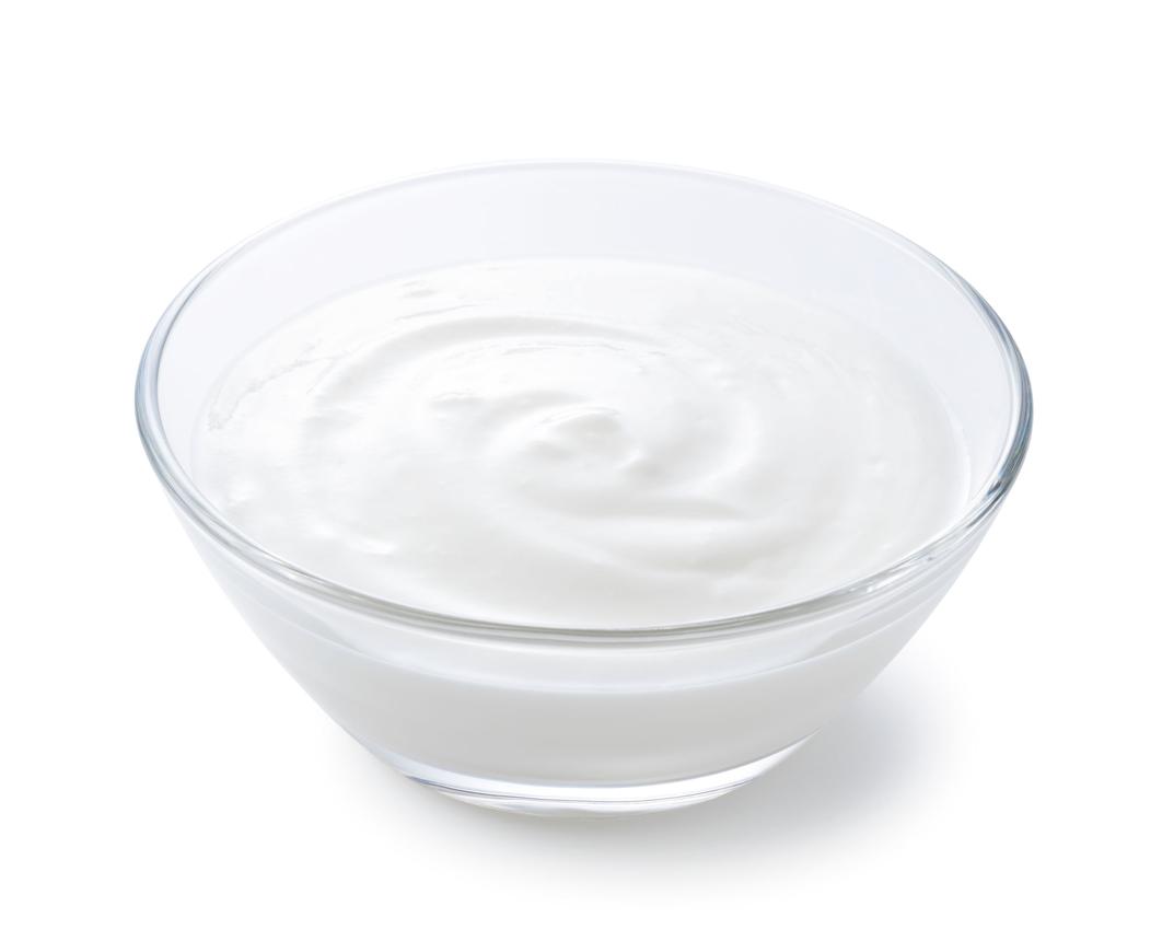 Yogurt in a glass bowl set against a white background